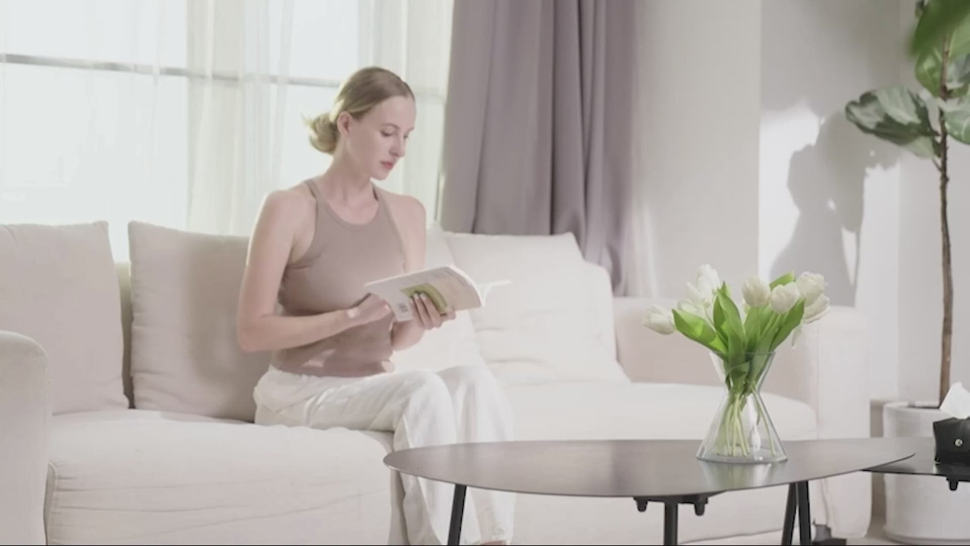 Woman relaxing on a sofa while using a shiatsu neck and back massager with deep tissue and heating features for soothing relief